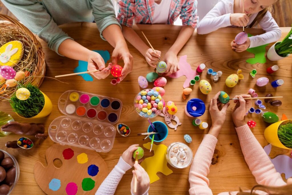 Family decorating easter eggs at the kitchen table, at-home Easter activities concept